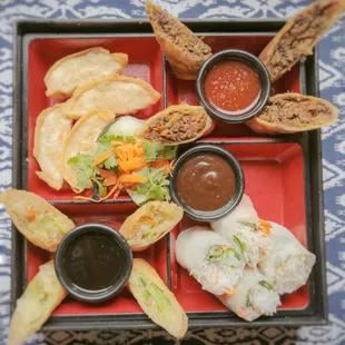 a plate of food with dipping sauces