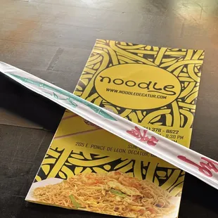 a box of noodles and a pair of chopsticks