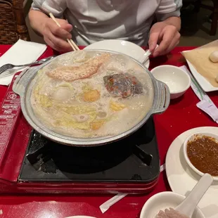 a woman preparing a hot pot of food