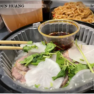Signature Lanzhou Beef Noodles w/broth in background (To-go order)