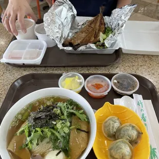 Fried mackerel with side dishes in top photo. Cold noodles in beef broth with side of steamed beef and leeks dumplings.