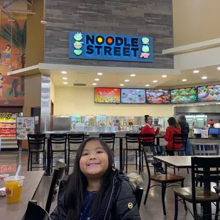 a woman sitting at a table in a restaurant