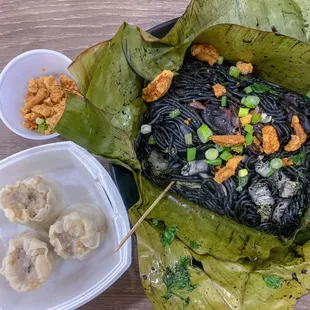 Pancit pusit (squid ink noodles) and pork siomai (shumai).