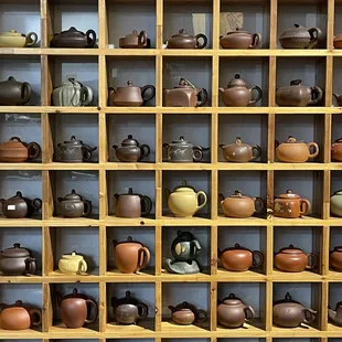 a shelf of teapots and teapots