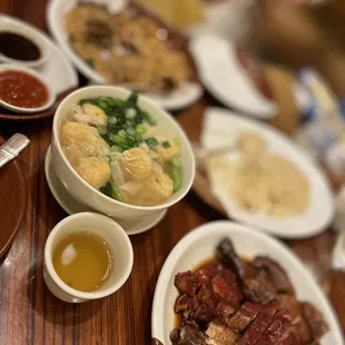 a variety of dishes of food on a wooden table