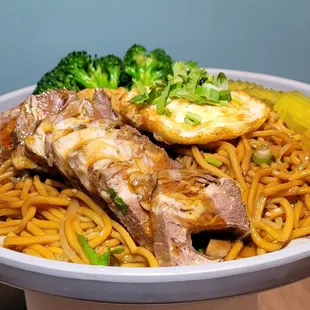 a plate of noodles and meat