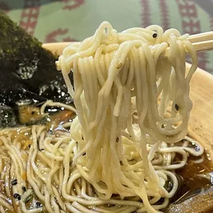 noodles being lifted by chopsticks