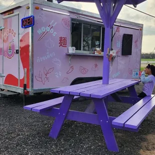 a purple picnic table and food truck