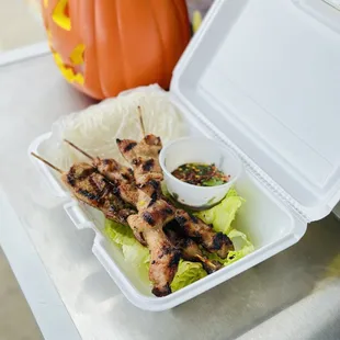 chicken skewers in a styrofoam container