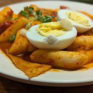 Tteokbokki ( Soft rice cakes in a spicy red chili sauce ) with Fish Cake and Sausage. A boiled egg is also on top