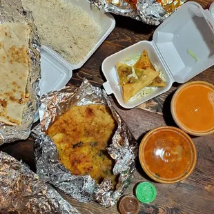 (clockwise) tandoori chicken, samosa, butter chicken, Chana Masala, aloo paratha, naan, rice