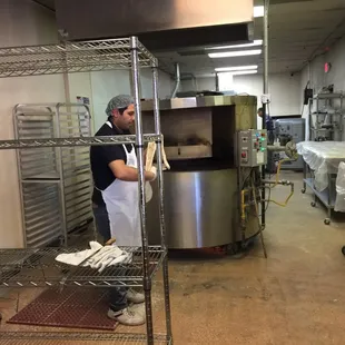 Stretching the dough before putting it on the grill behind.