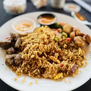 a plate of fried rice with meat and vegetables