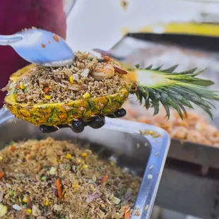 a pineapple being served with rice and vegetables