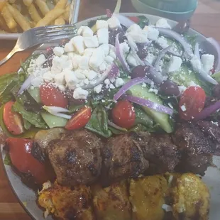 Beef and chicken kabob with Greek salad .
