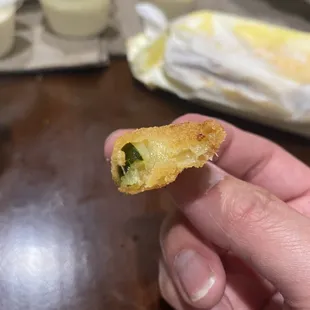 a hand holding a half eaten sandwich