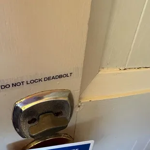 Sign above deadbolt that had locking mechanism removed