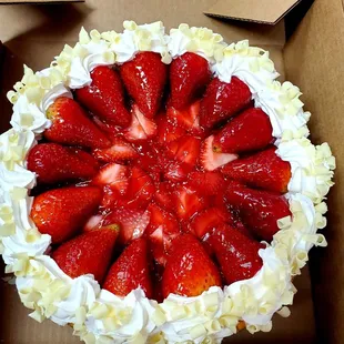 NYC chesse cake with strawberries, white chocolate shavings and cream.