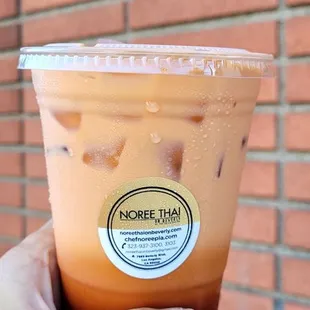 a hand holding a cup of iced coffee