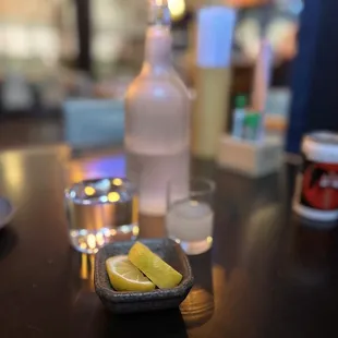 Classy water bottle, lemon wedges &amp; shot of sake