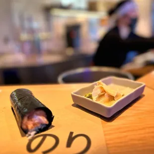 a roll of sushi and a bowl of sauce