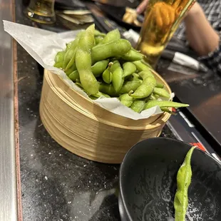 a bowl of edamado and a glass of beer