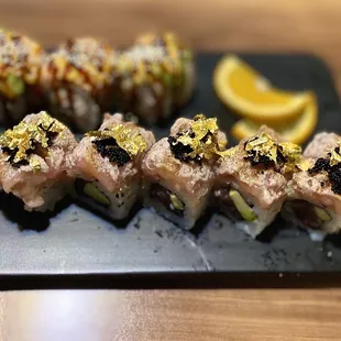a plate of sushi with a slice of lemon