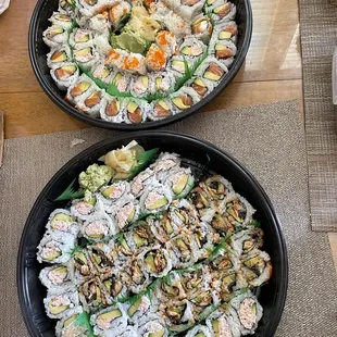 two plates of sushi and a bowl of salad