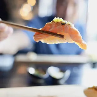 a person eating sushi with chopsticks