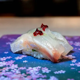 a piece of sushi on a purple and blue napkin