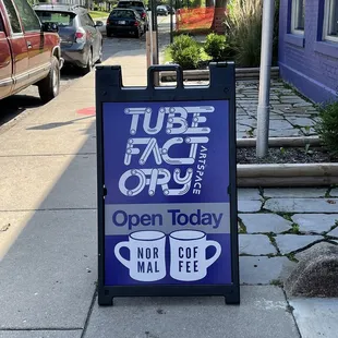 a sign on a sidewalk in front of a building