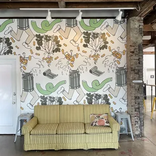 a couch in front of a wall mural