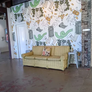 a couch in a room with a mural on the wall