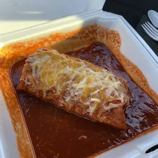 Carne asada burrito served wet with mild red homemade enchilada sauce