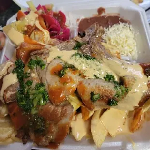 Chuleta con Tajadas: Pork chop with fried plantain strips, cabbage salad, pico de gallo, refried beans