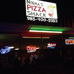 a neon sign in front of the restaurant