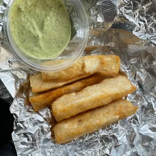 a bowl of dip and some fried breadsticks