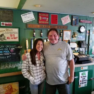 a man and a woman standing in front of a bar