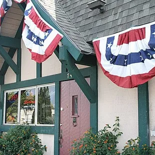 a red, white, and blue flag hanging from the side of a building