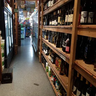 a narrow aisle of wine bottles