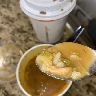a spoon full of soup and a cup of coffee
