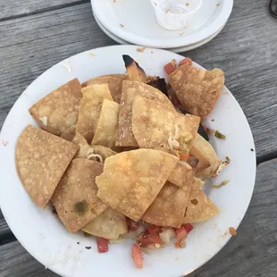 a plate of nachos on a picnic table