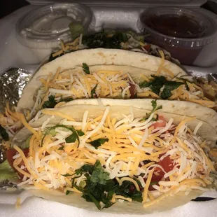 two tacos with cheese and lettuce