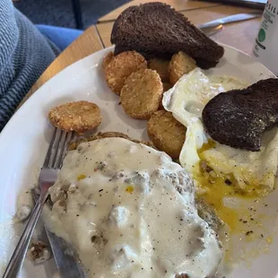 Chicken fried steak and eggs with fried potatoes