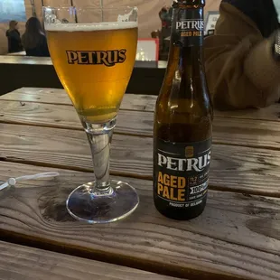 a glass of beer and a bottle on a table