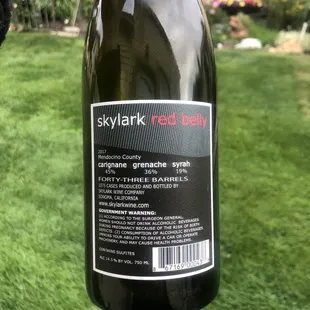 a hand holding a bottle of wine