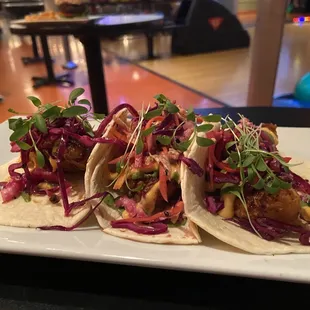 three tacos on a white plate