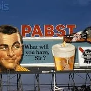 a billboard with a man pouring beer