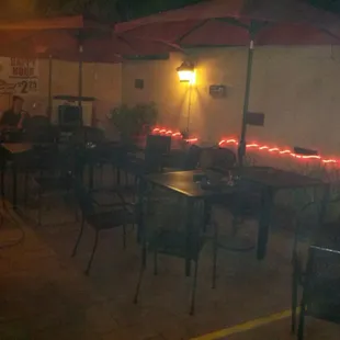 tables and umbrellas lit up at night