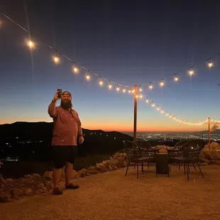 a man taking a picture of the sunset